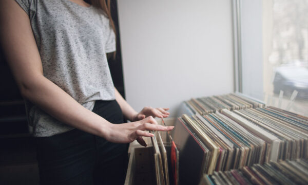 Choosing retro vinyl records. Music background. Unrecognizable woman in musical shop, old school hipster style